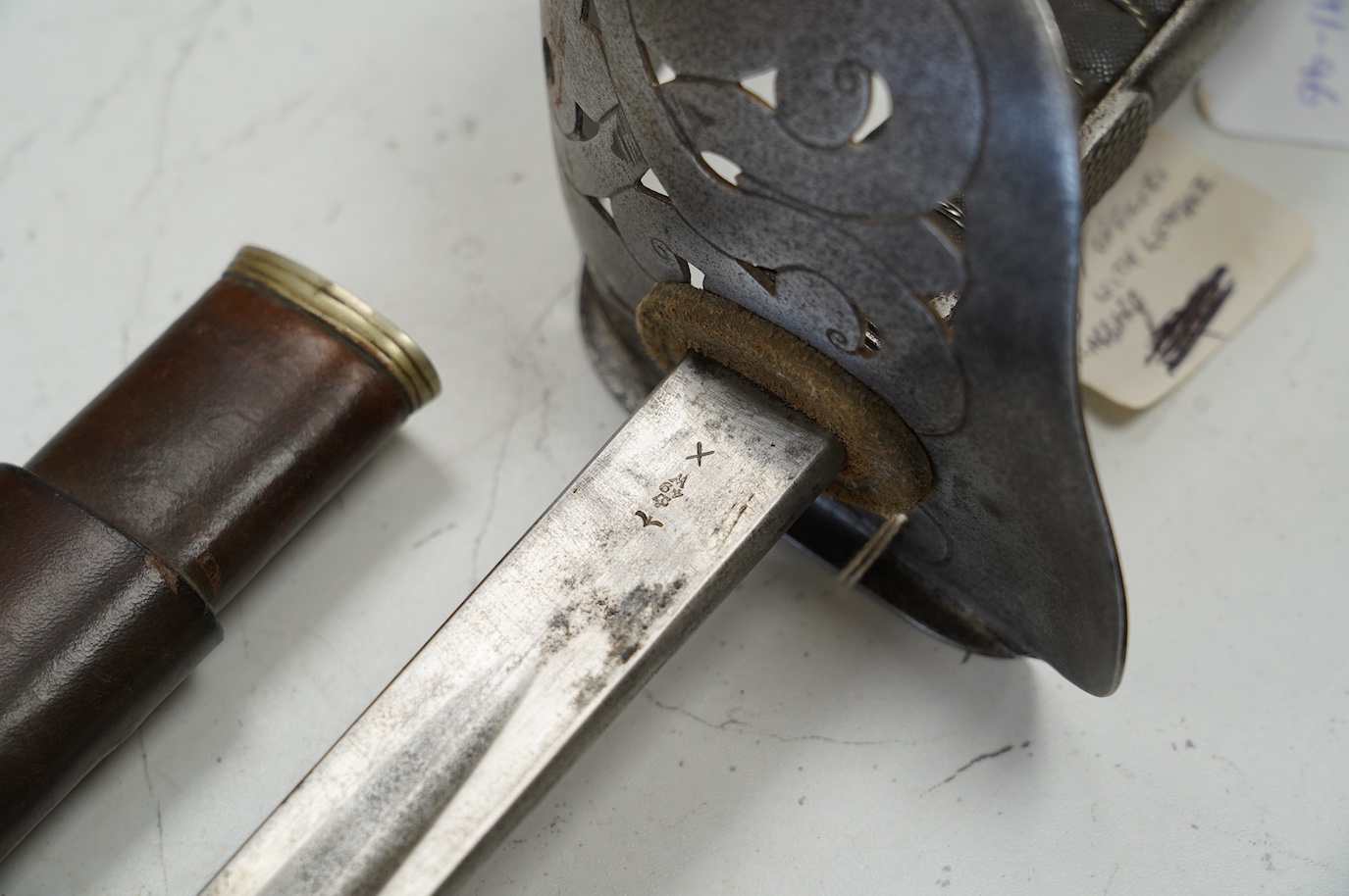 An 1898 pattern British NCO’s sword with leather scabbard, Edward VII cipher to guard, the blade with government stamps, issued 1903, blade 82cm. Condition - fair, some wear overall